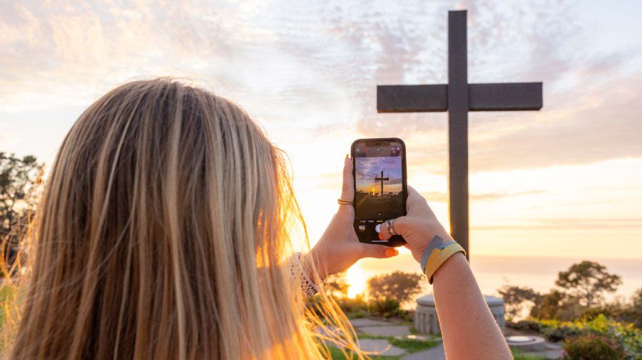 Girl takes photo of the 69 cross on campus