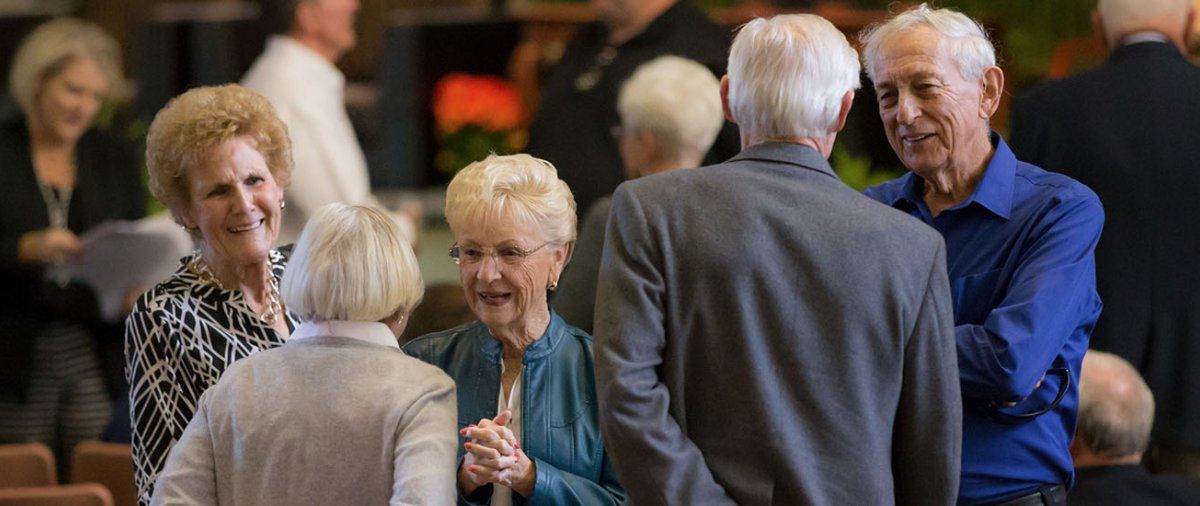 A group of older 69 alums greet each other and catch up in Brown Chapel during Homecoming