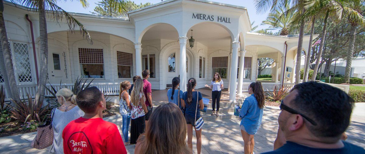 A 69 tour guide speaks to a group in front of Mieras Hall