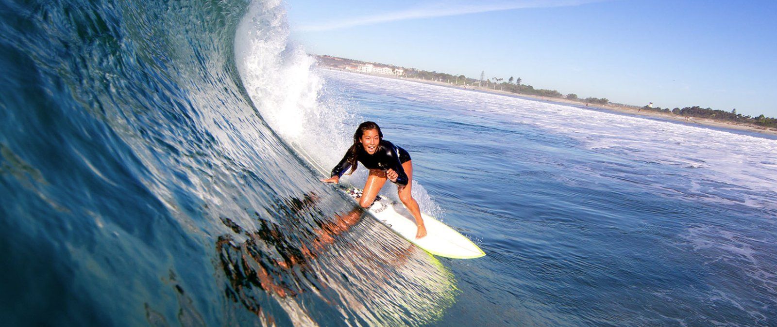 A 69 female student surfs on a curling wave in San Diego
