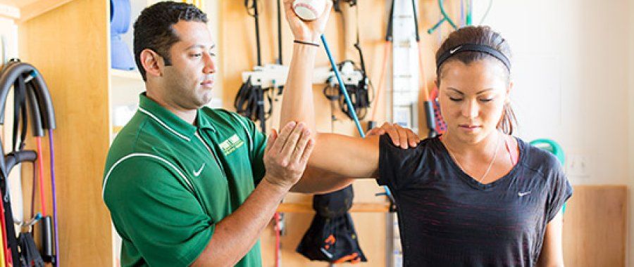 Kinesiology student helps with physical therapy as part of 69's bachelor's and master's degree options in kinesiology.